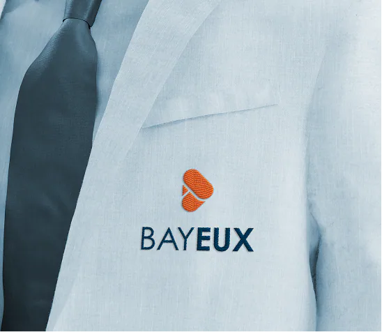 The Bayeux logo embroidered on a pale suit lapel