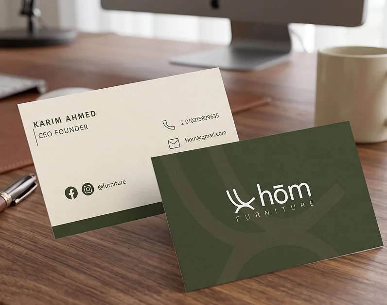 hōm business cards in Rifle Green and cream on a desk