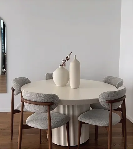 A round dining table with grey upholstered chairs