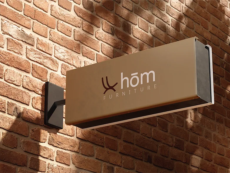 The hōm furniture shop sign on a brick wall