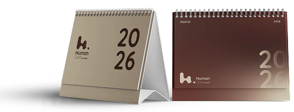 Two Human Care 2026 desk calendars, one cream and one maroon