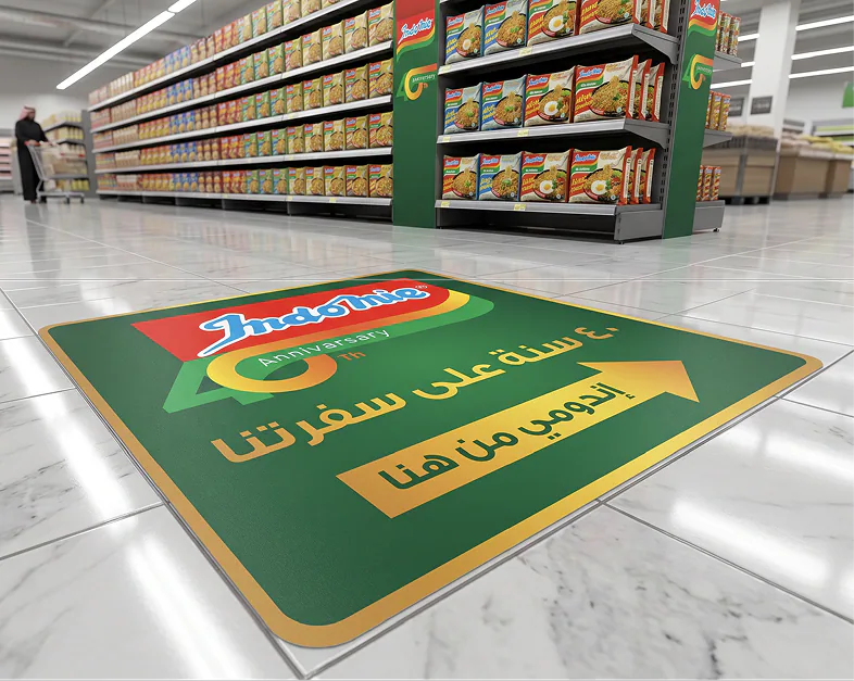 An Indomie 40th anniversary floor graphic in a supermarket aisle pointing shoppers to the display