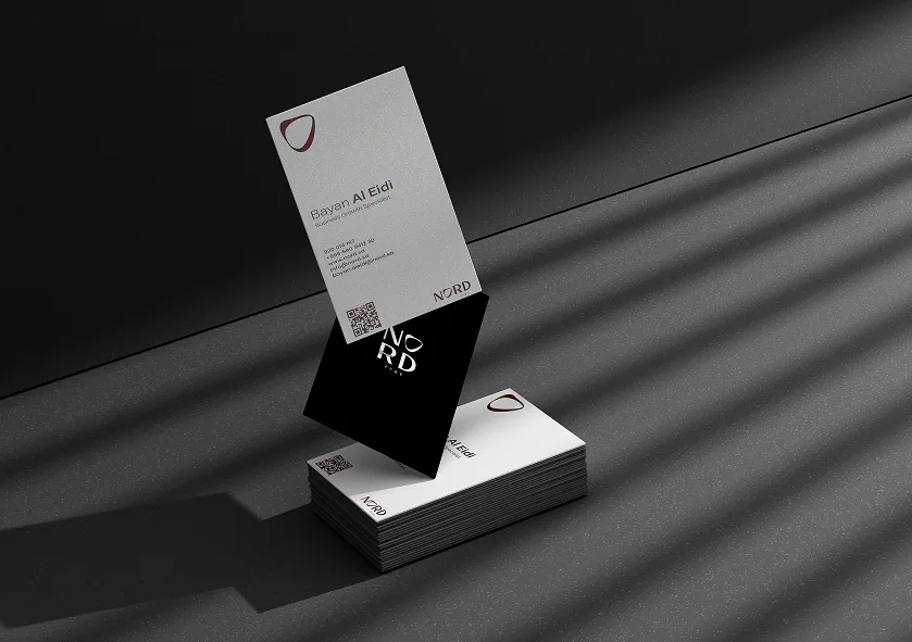 The Nord business card, front and back, standing on a dark surface