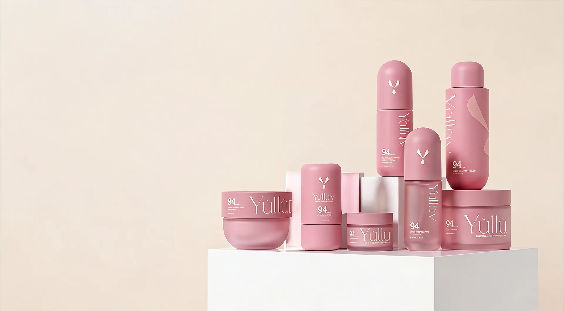 A complete collection of pink Yulluv skincare packaging on a cream studio set