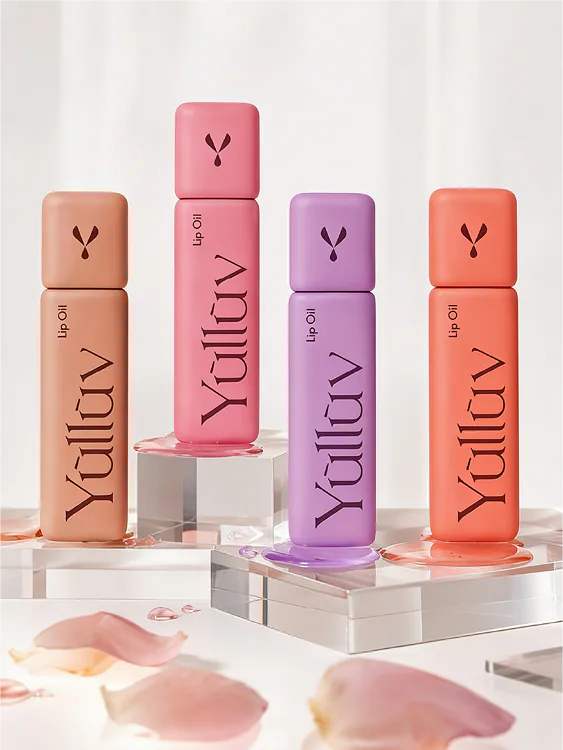 Four Yulluv lip oils displayed on clear acrylic plinths